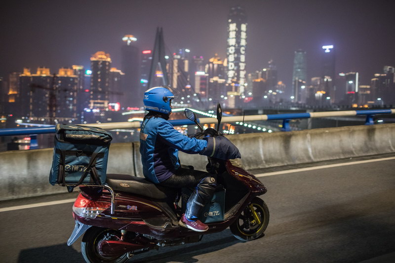 Food delivery driver rides on the road at night