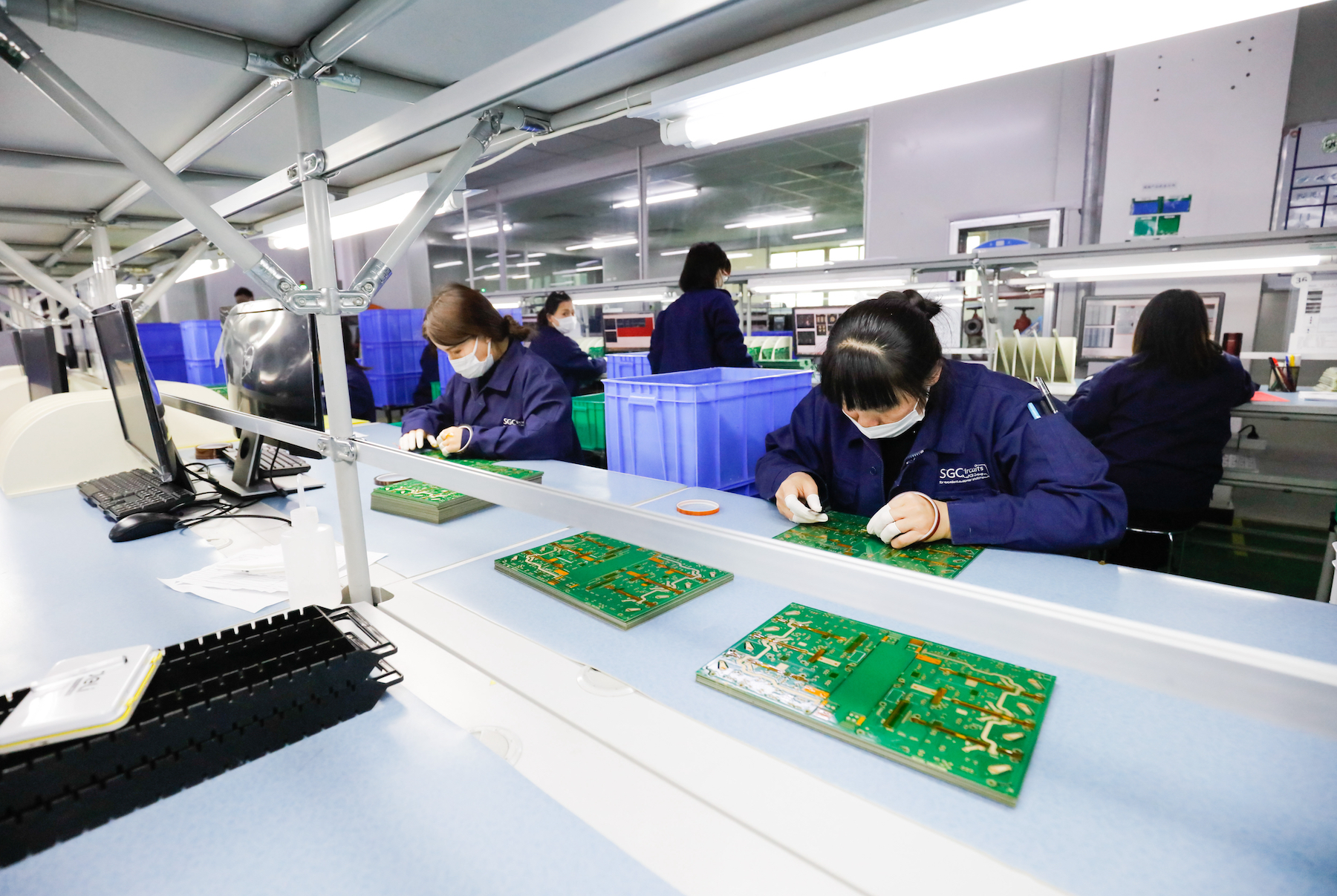 Factory workers assemble circuit boards