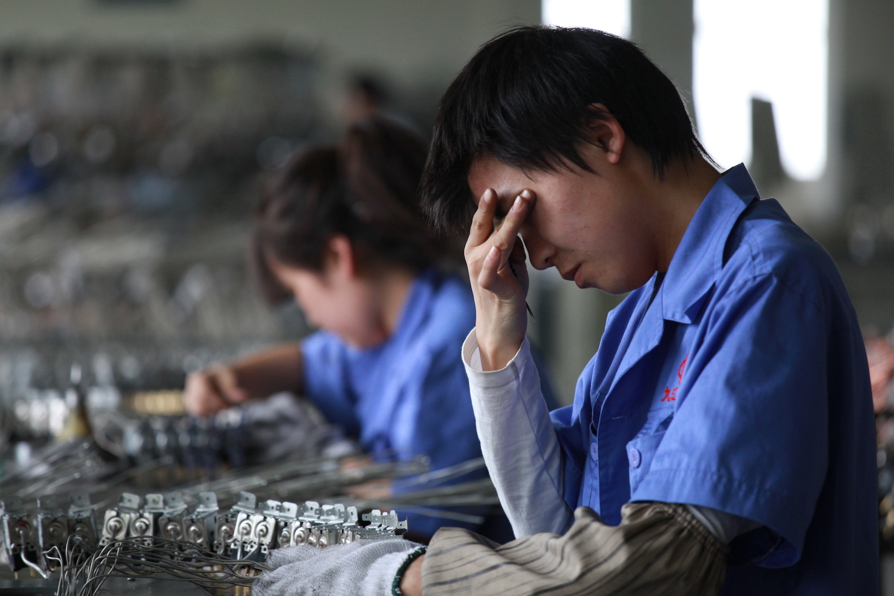 Factory workers at an electronics factory work on the production line
