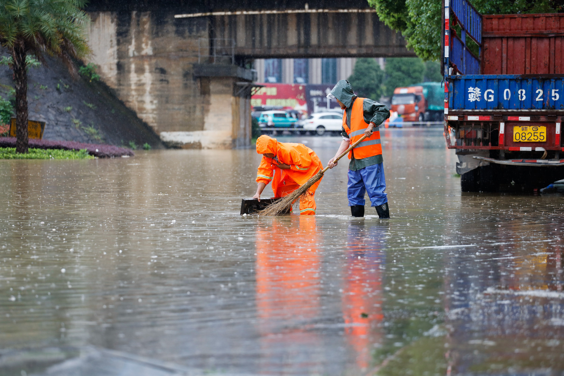 Sanitation workers work in a flooded road