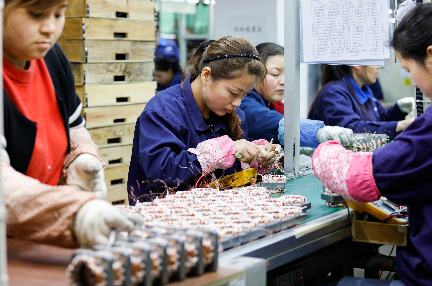 Workers assemble components in an electronics factory