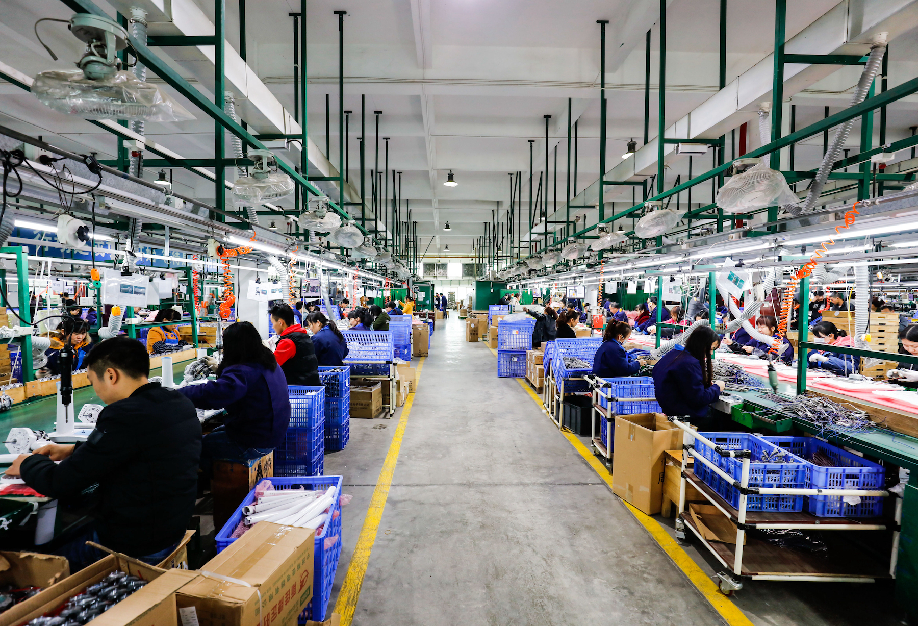 Dozens of factory workers perform labour in an electronics workshop