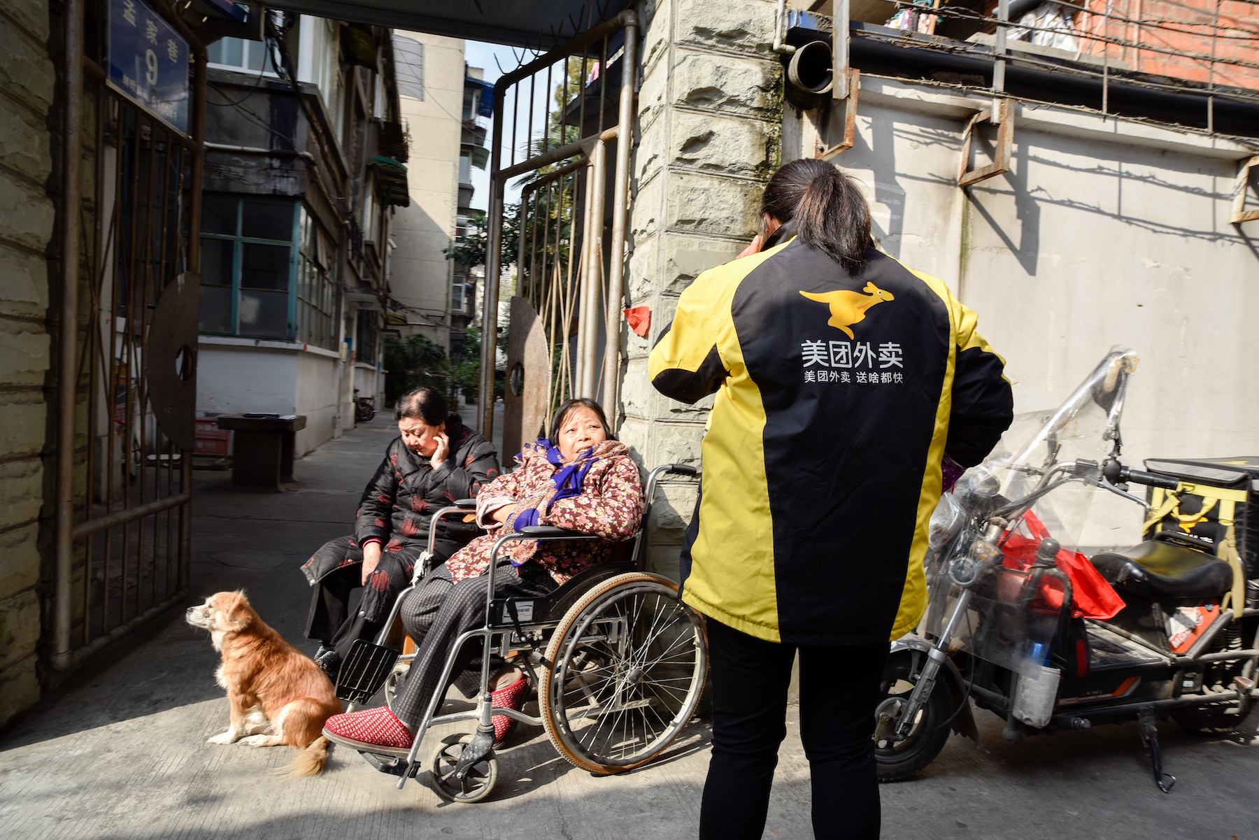A female Meituan food delivery rider delivers food to elderly residents