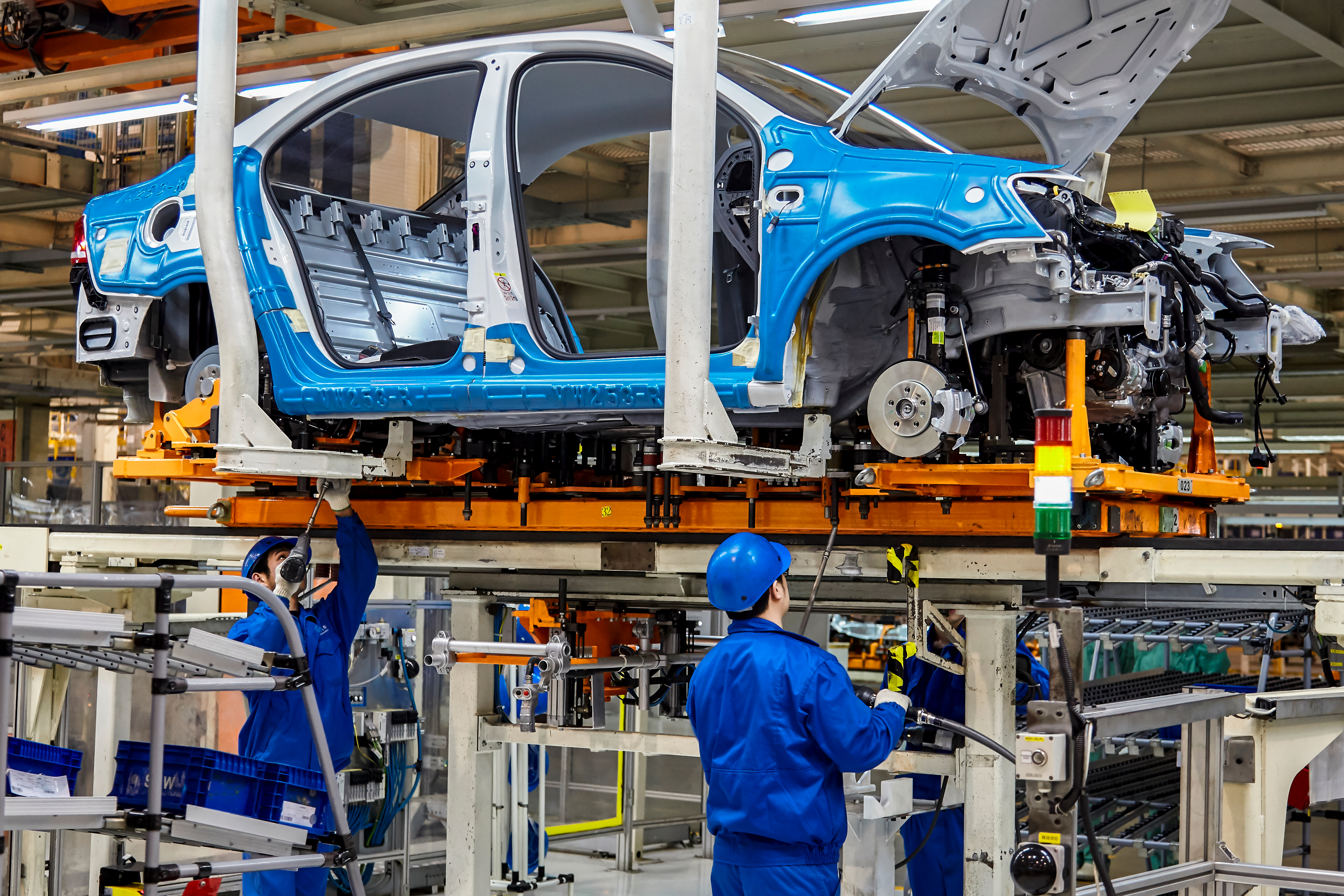 Photo: workers installing car chassis in the Shanghai Volkswagen production plant Photo credit: Jenson / Shutterstock.com