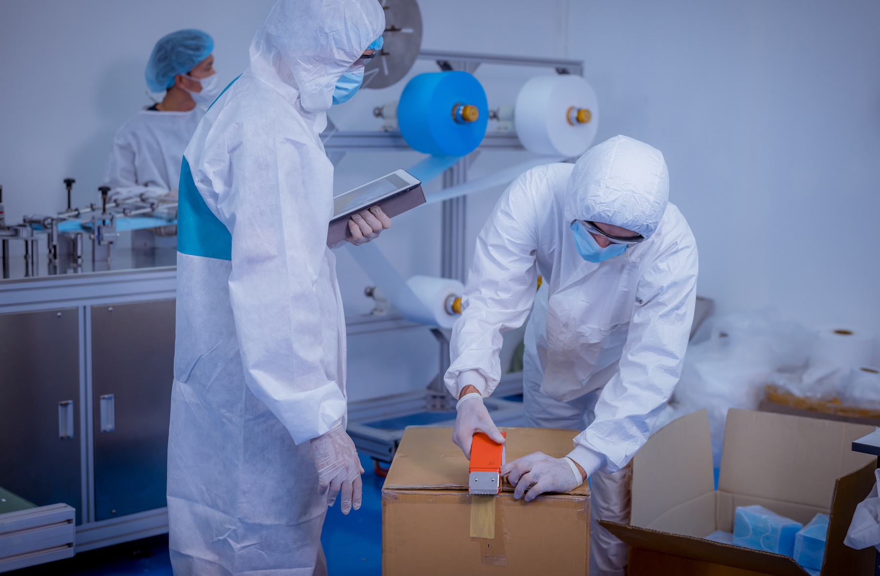 Workers in a medical supply factory pack boxes for shipment