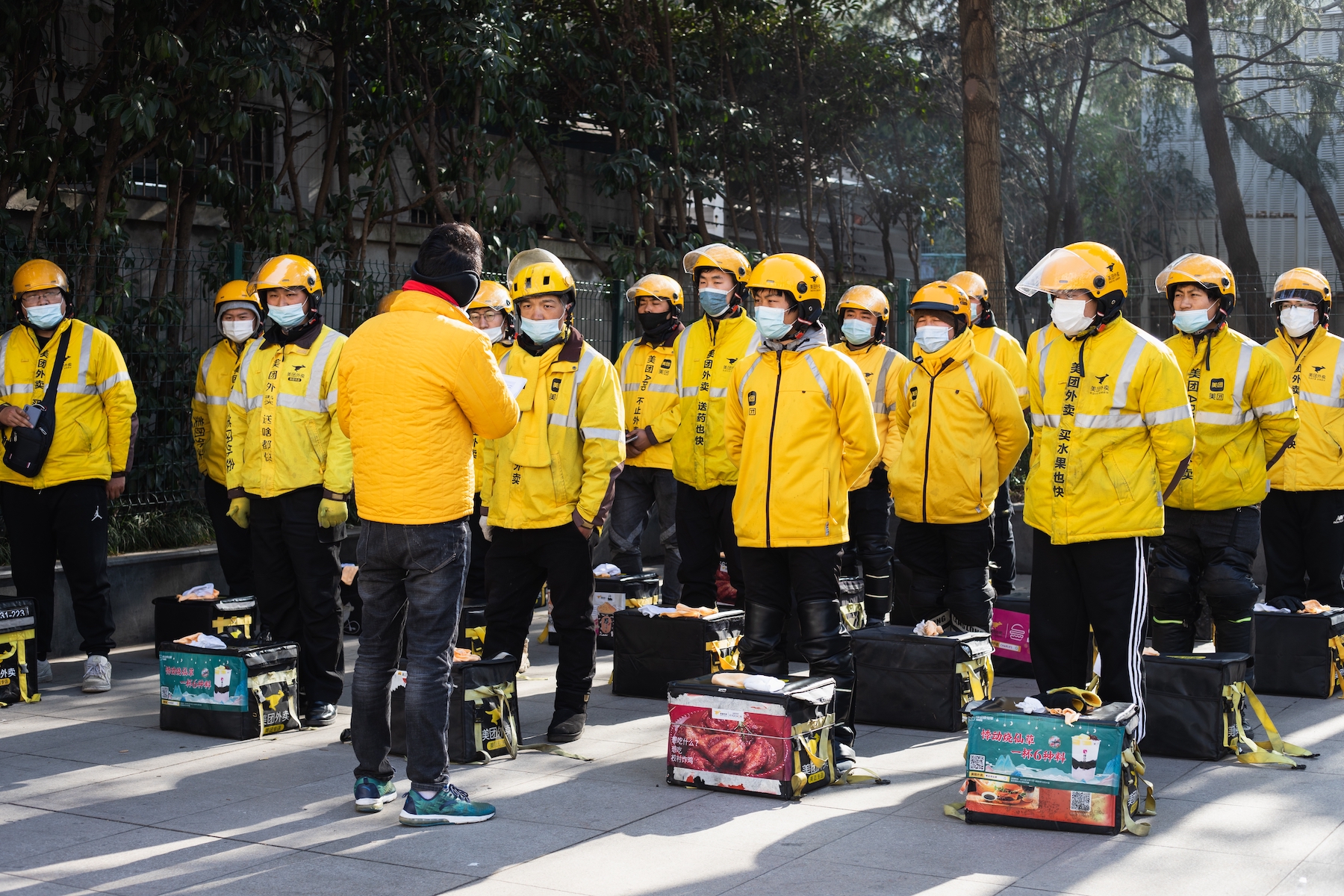 Meituan food delivery workers gather at their substation before work to participate in morning exercises and receive instructions